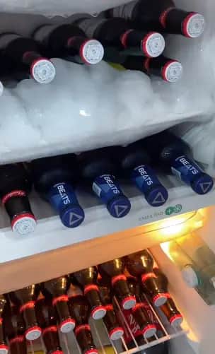 Interior da geladeira da barbearia com cervejas e long necks Beats gelados