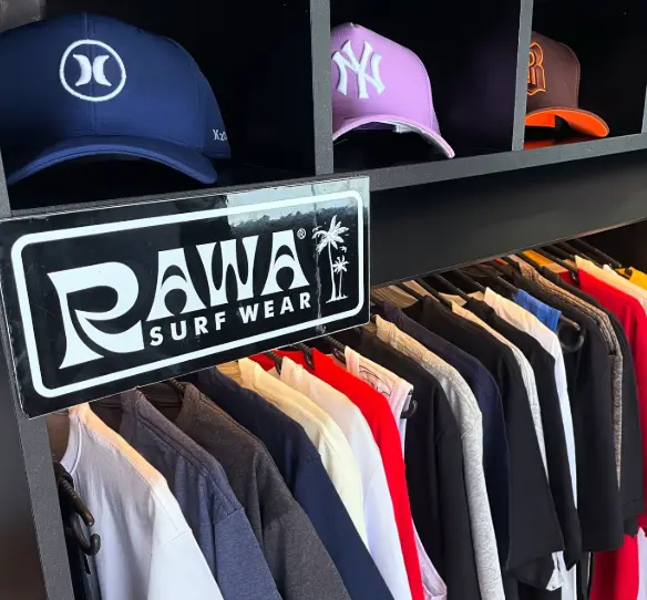 Peças da Rawa Surf Wear expostas na loja da barbearia, em Curitiba