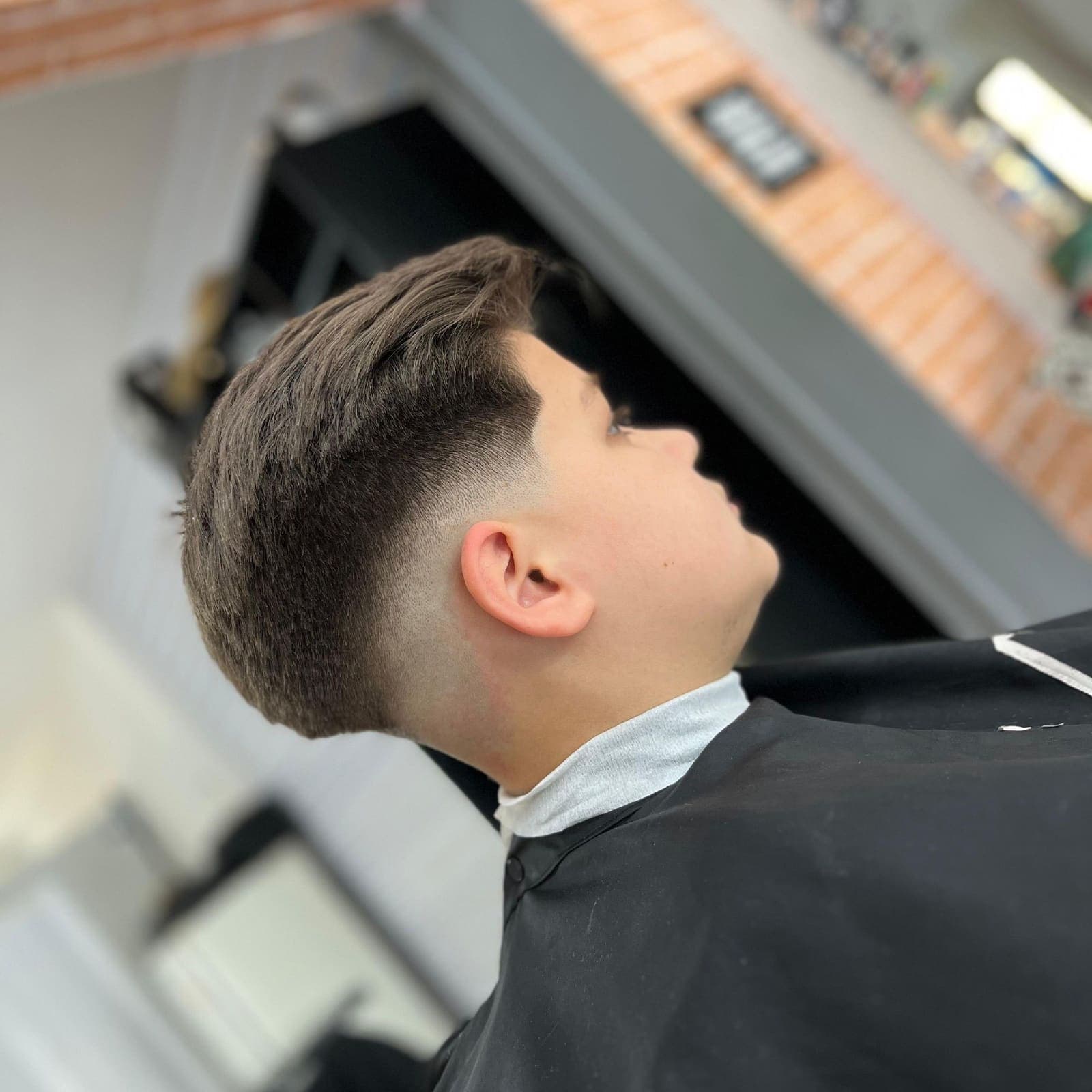 Barbeiro trabalhando o acabamento do corte na Dom Elii Barbershop